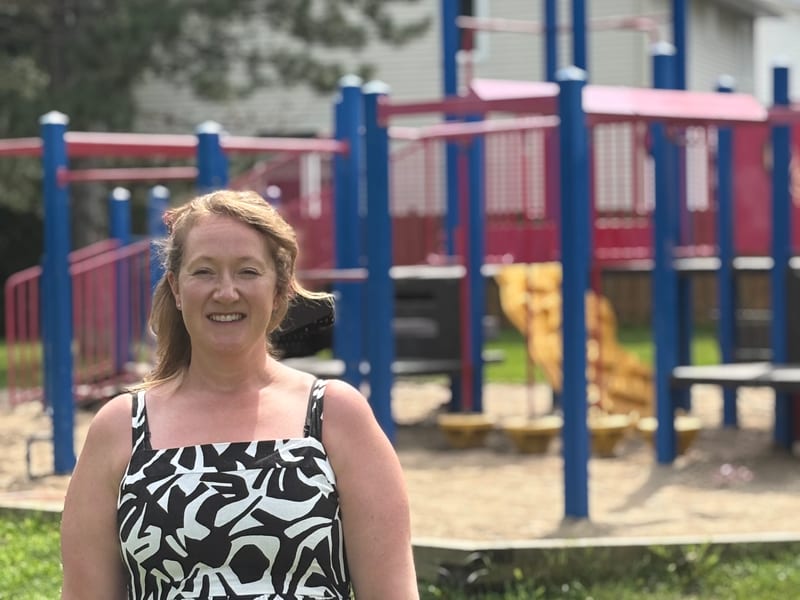 Jenna Jessop standing in front of a neighbourhood playground