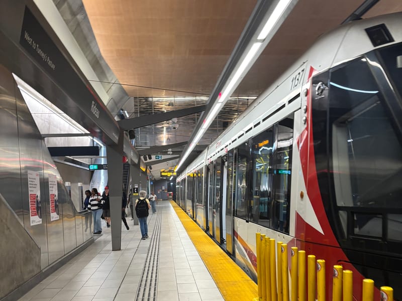 An O-Train Confederation Line train stopped at a station platform